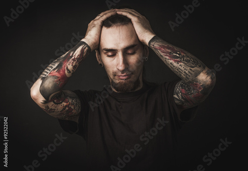 Portrait of a man with naked torso and tattooes