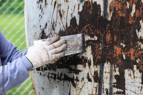 Remove old paint by trowel for surface preparation (hand and trowel moving for scrape pint)