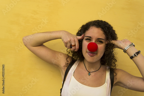 Mujer joven haciendo burlas con nariz de payaso photo