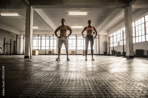 Crossfit couple facing camera with hands on hips