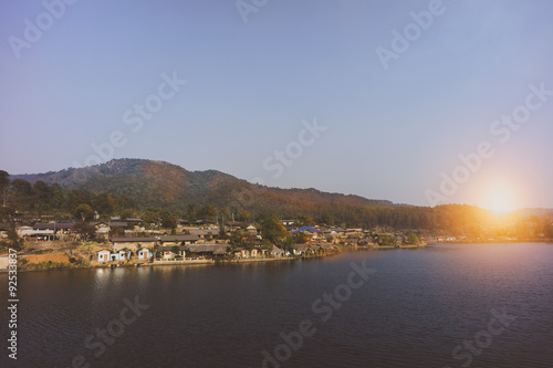 small village at the lake with sunset behind a mountain