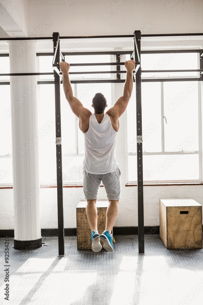 Fototapeta premium Rear view of man doing pull ups