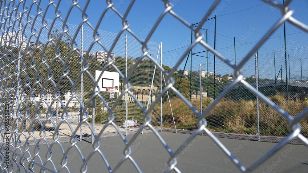 Terrain de basket derrière de grillage Terrain de basket derrière de grillage