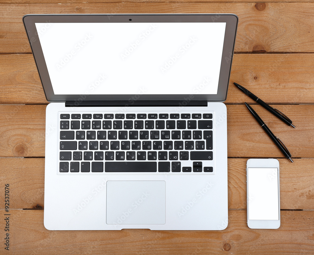 Pens and smart phone near open notebook on wooden background, top view Pens and smart phone near open notebook on wooden background, top view