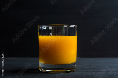 Fresh made peach juice on black wooden background