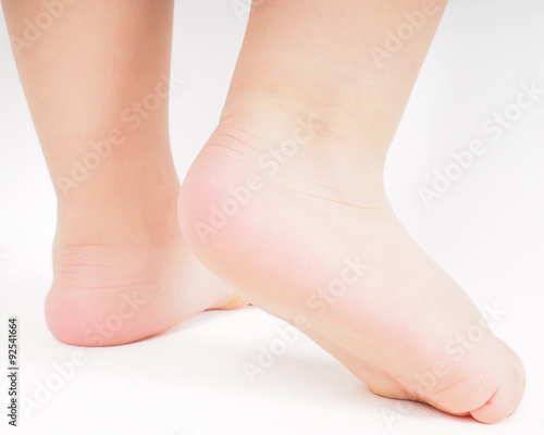 Little person walking away barefoot towards bright background