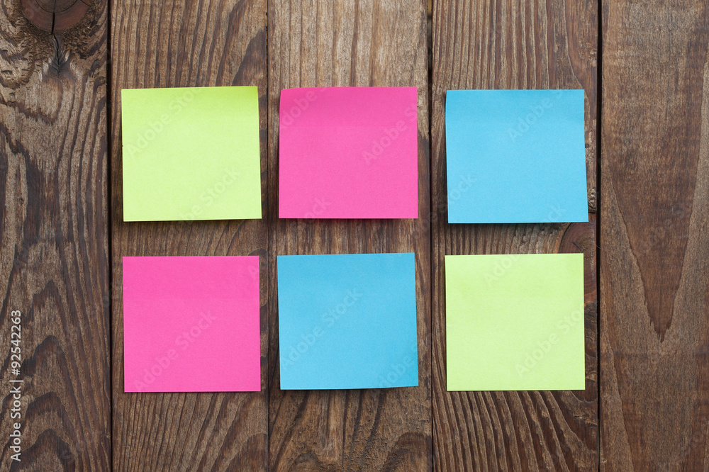 Multicolored paper stickers note on wooden background. Multicolored paper stickers note on wooden background.