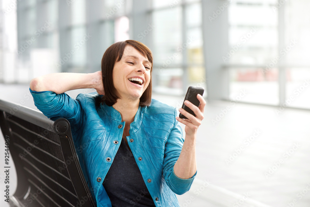 Fototapeta premium Older woman reading text message and laughing