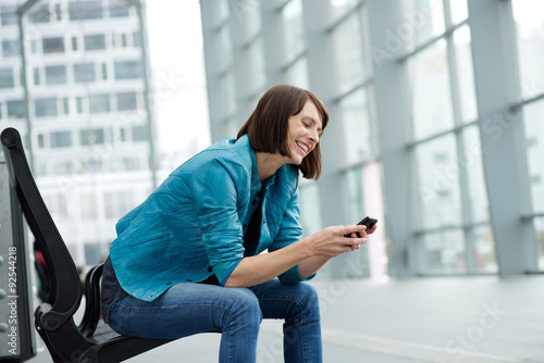 Free Download Smiling older woman sitting with mobile phone - GFXLoad