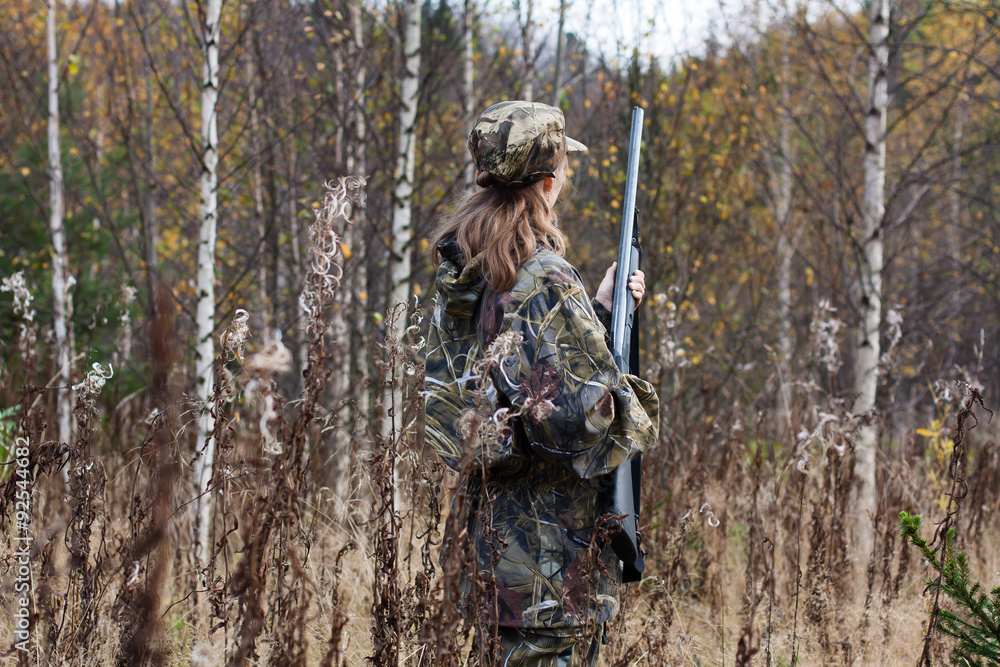 Woman hunter shooting in the forest
