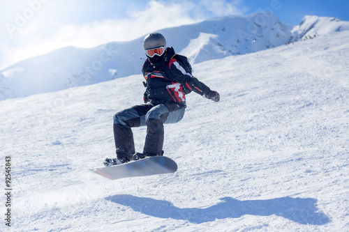 Snowboarder at jump inhigh mountains