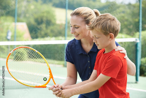 Female Tennis Coach Giving Lesson To Boy © highwaystarz