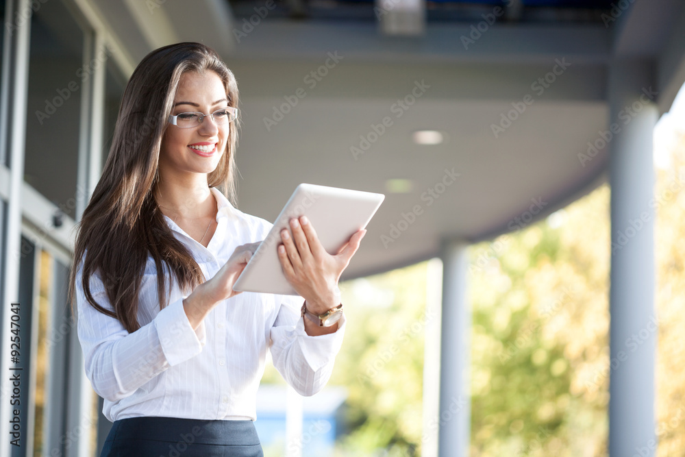 © V&P Photo Studio - Smiling businesswoman using electronic tablet outside © V&P Photo Studio - Smiling businesswoman using electronic tablet outside