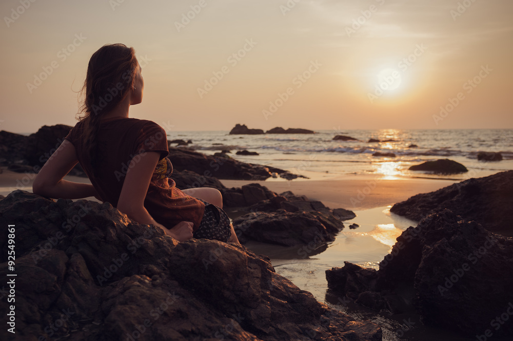 Woman admires the sunset on the beach
