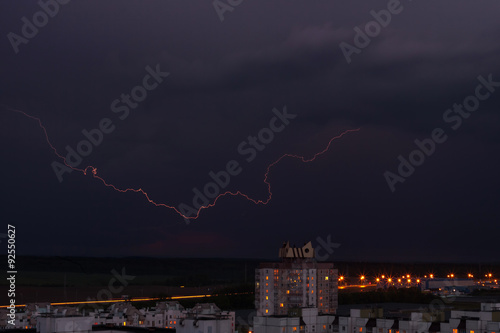 lightning in the night sky over the city houses