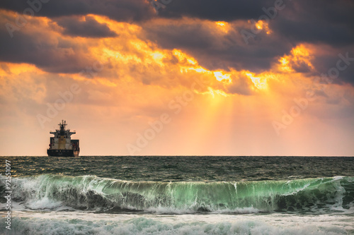 Cargo ship with containers in sunrise light