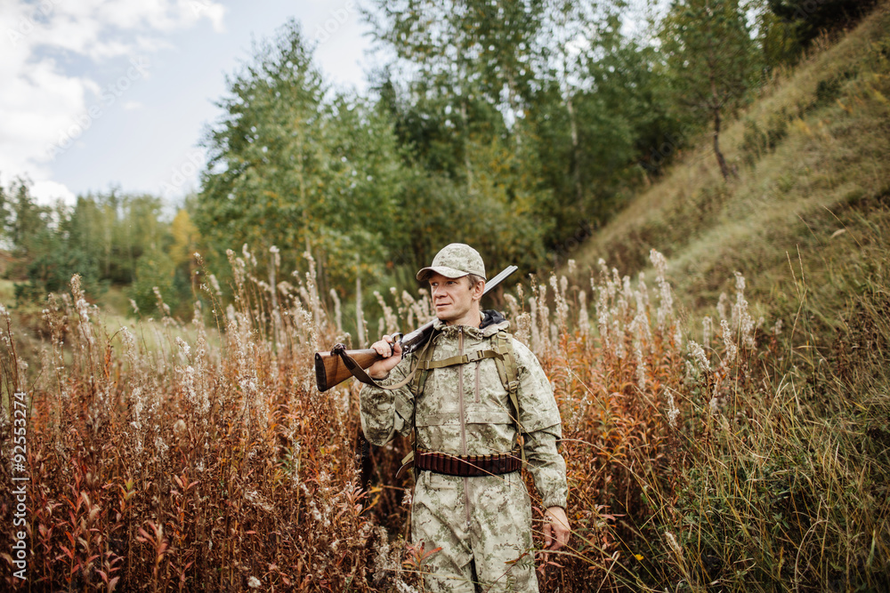 Fototapeta premium man hunter with shotgun in forest