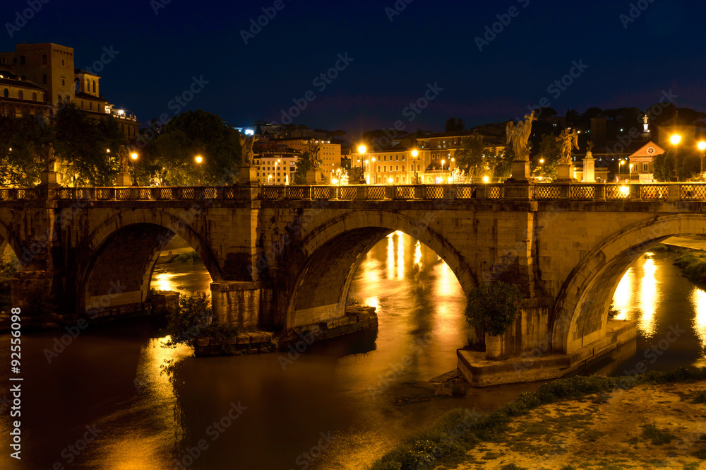 Old bridge over the Tiber in Rome lit at night