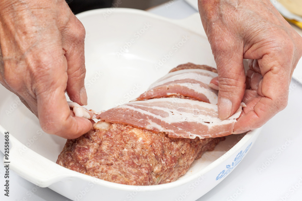 Cubriendo un rollo de carne crudo con tocineta