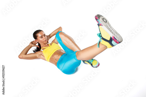 Young woman in colorfully sportswear doing exercise on white background