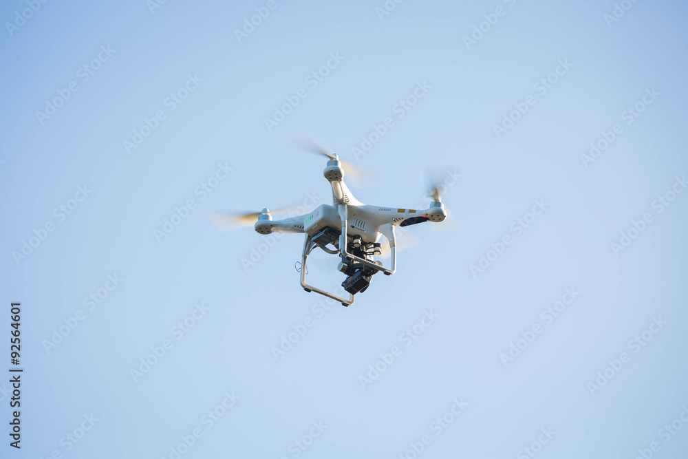 Drone hovering on the blue sky.