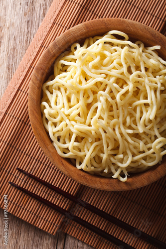 Asian ramen noodles in wooden bowl close-up. vertical top view
