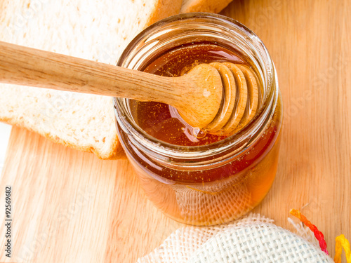 Golden honey with honeystick and bread photo