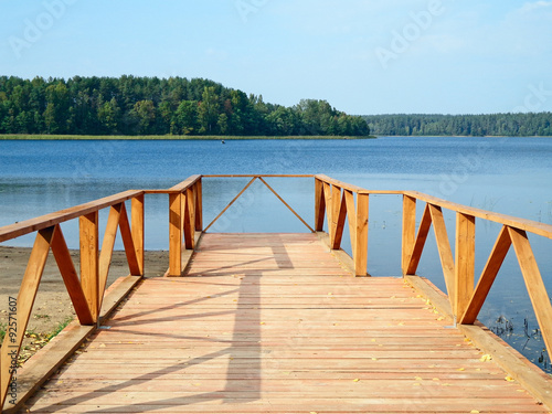 Tablou canvas Wooden footbridge on the shore of the lake