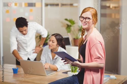 Portrait of businesswoman holding digital tablet in office