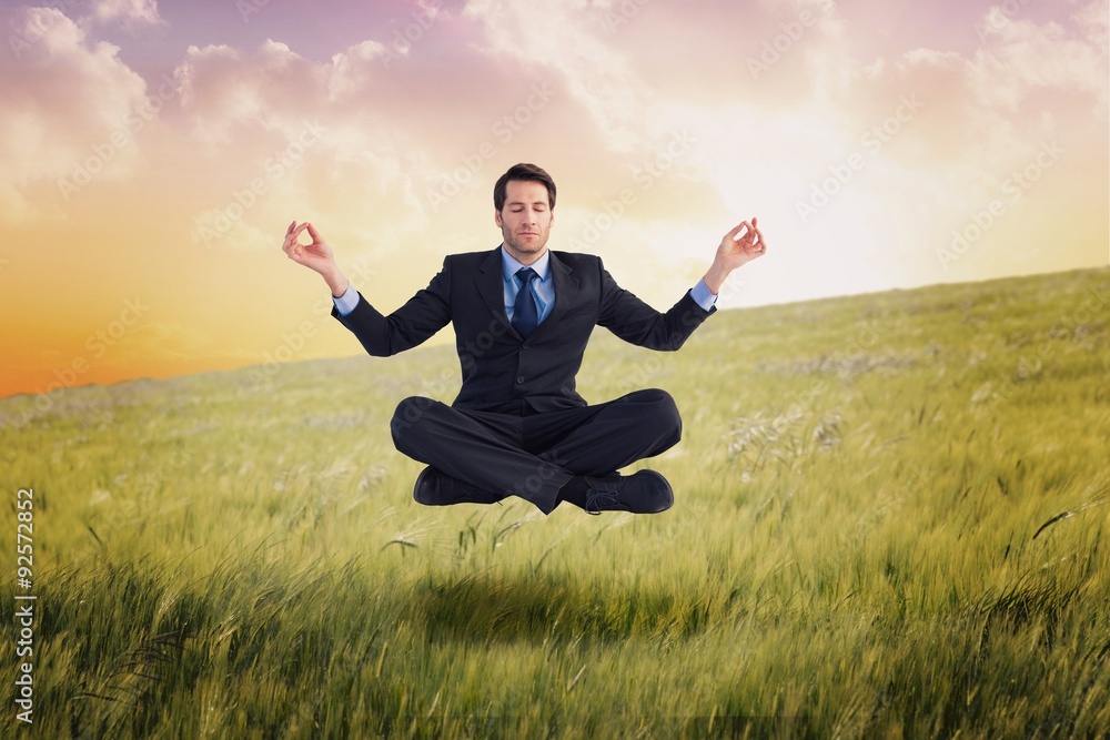 Composite image of calm businessman sitting in lotus pose Composite image of calm businessman sitting in lotus pose