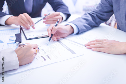 Photography Two businessmen looking at report and having a discussion in off