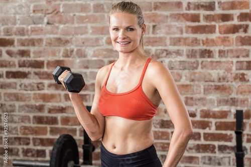 Fit woman exercising with dumbbell