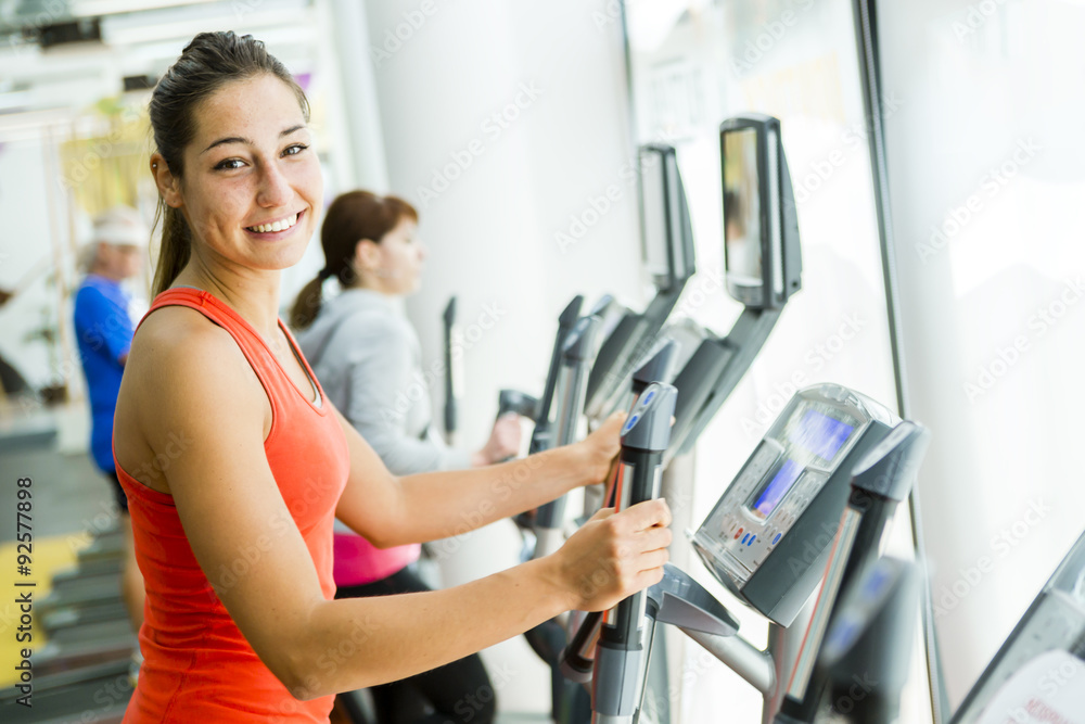 Young fit woman using an elliptic trainer Young fit woman using an elliptic trainer