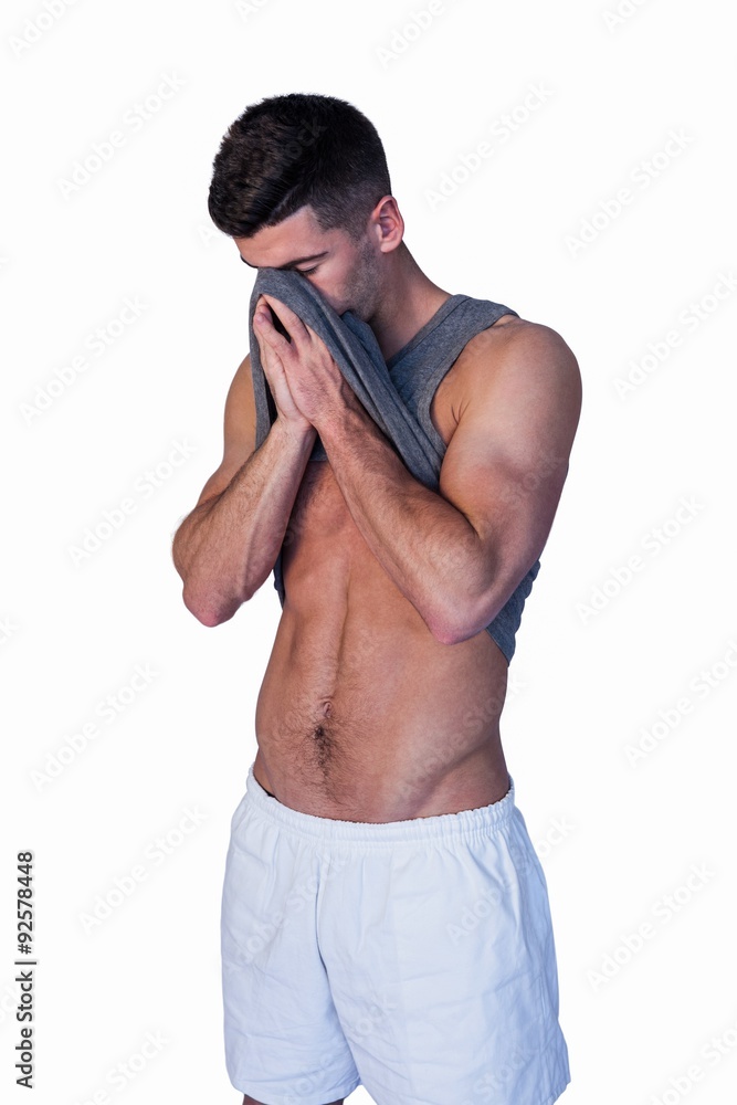 Fototapeta premium Man wiping his face with shirt