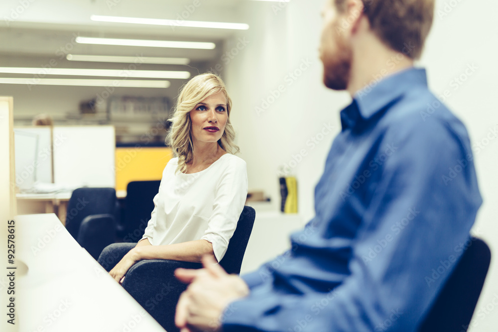 Obraz premium Beautiful blonde worker talking with colleague in office