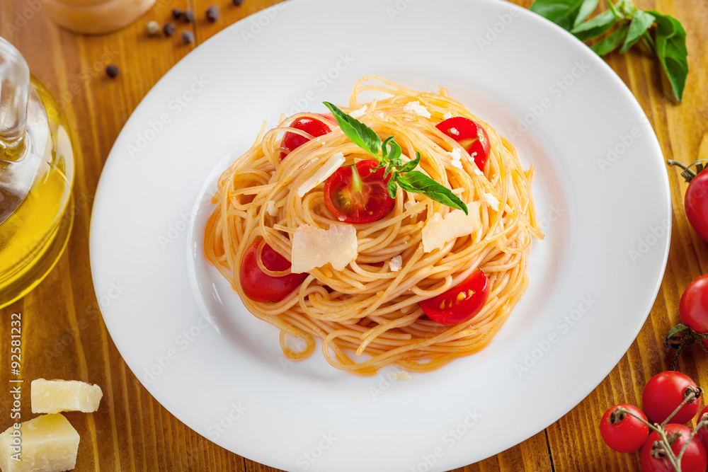 Italian pasta, spaghetti with tomato, parmesan and basil, top view, close-up. Italian pasta, spaghetti with tomato, parmesan and basil, top view, close-up.