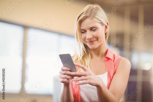 Beautiful businesswoman texting on phone