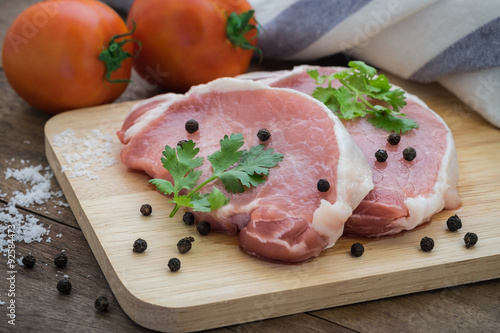 Raw pork meat sliced on wooden cutting board