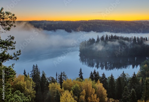Autumn landscape in the morning. Thick fog above a lake at Aulanko nature reserve park in Finland. 