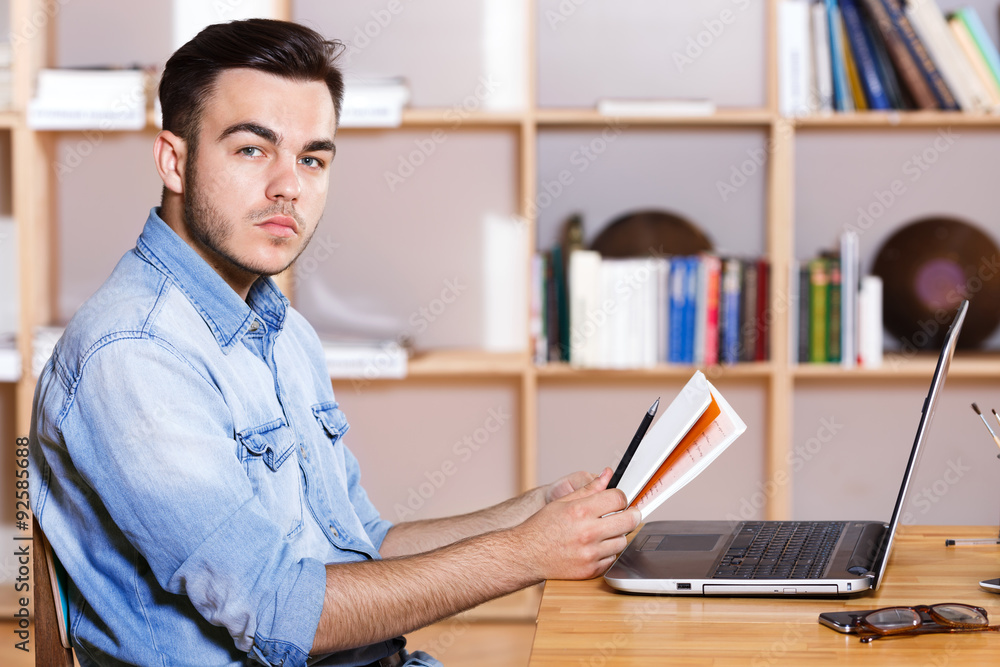 Obraz premium Side view of a handsome businessman sitting at the table
