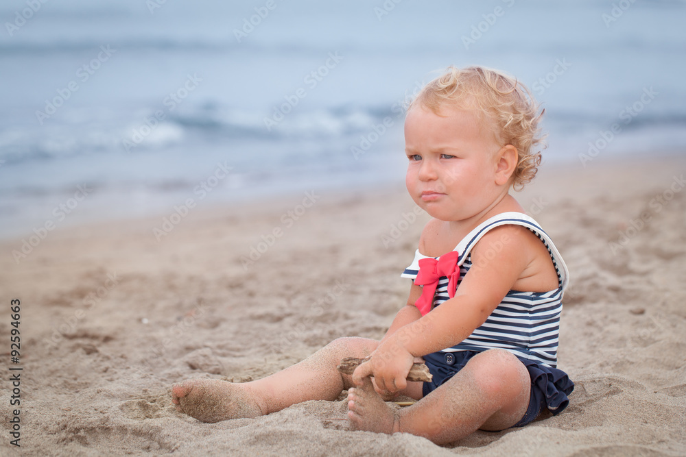 Small pretty baby girl walking along seashore