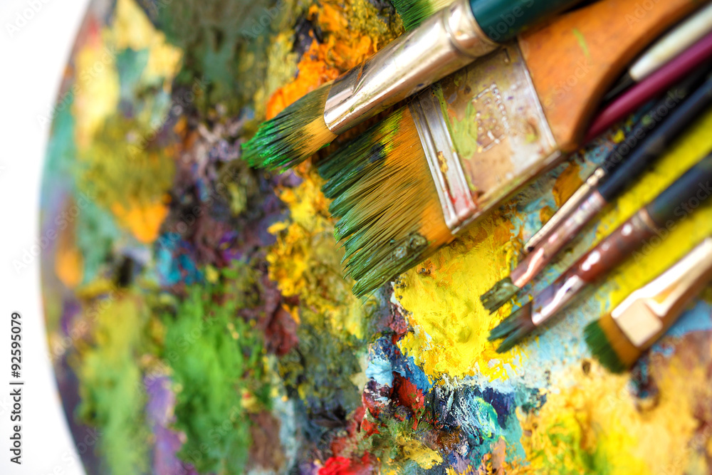 Fototapeta premium Paint brushes, painting palette with colors on white background