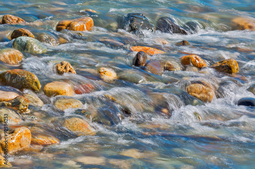 Pebble stones in the river water close up view,