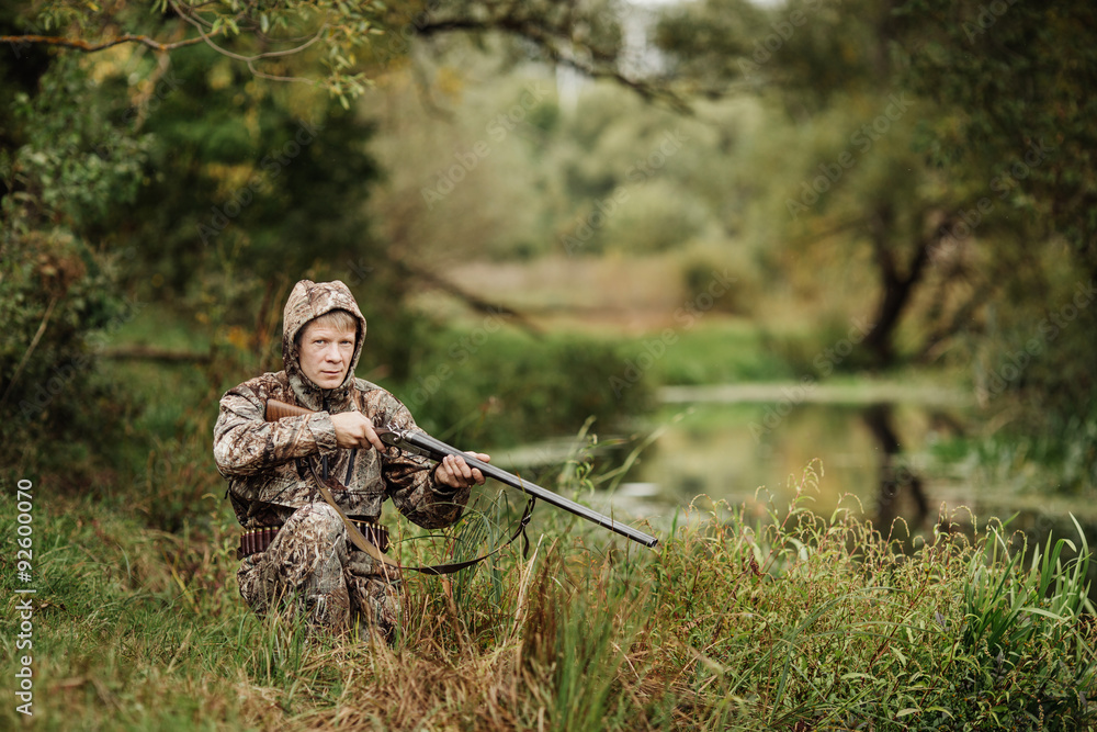 Fototapeta premium hunter in camouflage clothes ready to hunt with hunting rifle