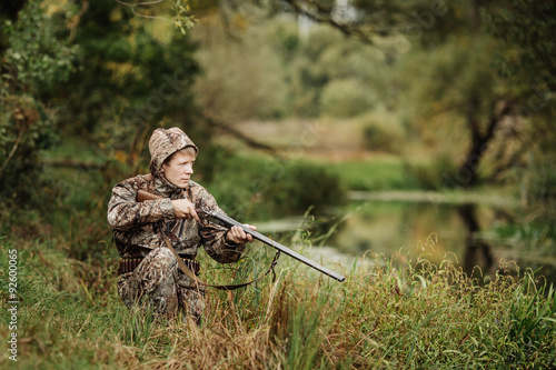 hunter in camouflage clothes ready to hunt with hunting rifle