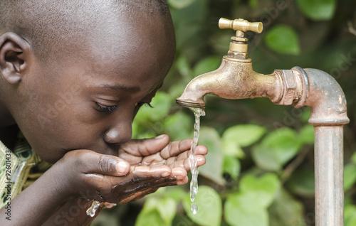 Proud Black Boy Drinking from a Water Tap Africa