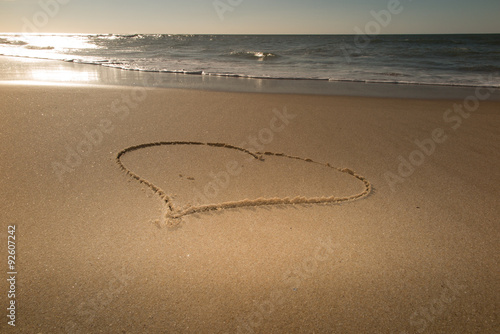 Beautiful heart in sand at the beach - love symbol photo