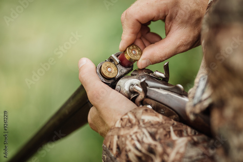 hunter in camouflage clothes ready to hunt with hunting rifle