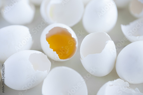 Broken eggs. Closeup view of broken eggs with yolk inside one of them. 