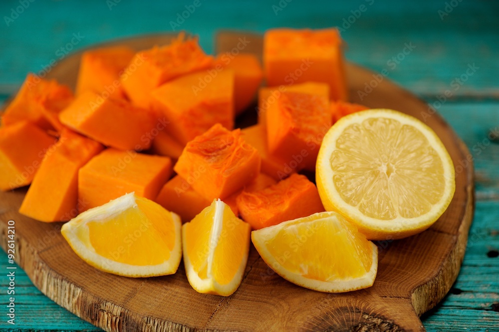 Sweet pumpkin, orange and lemon cut on wooden board Sweet pumpkin, orange and lemon cut on wooden board
